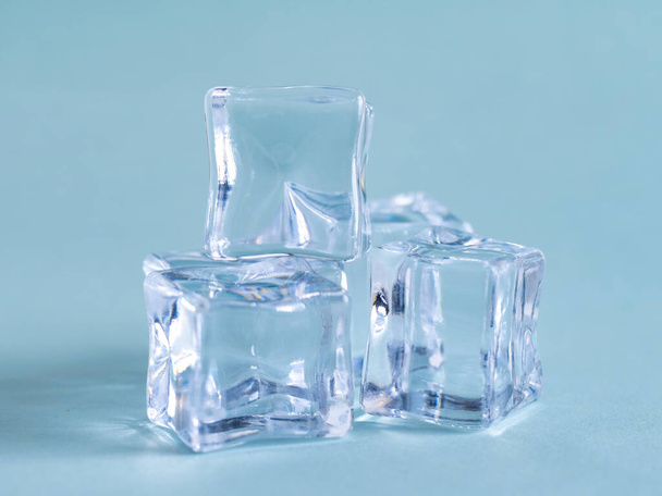 Pile of plastic ice cubes isolated on blue background, object - 写真・画像
