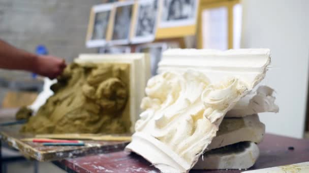 Rzeźbiarz tworzy glinowy model mieszkańca Koryntu ze zwojami i listkami akanty w pracowni konserwatorskiej - Materiał filmowy, wideo