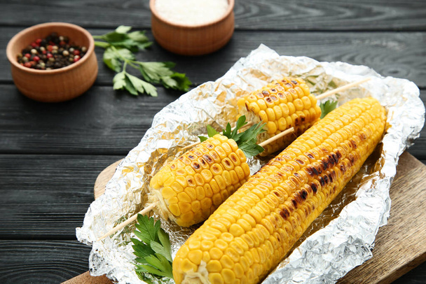 Grilled corn with green parsley on wooden table - Фото, зображення