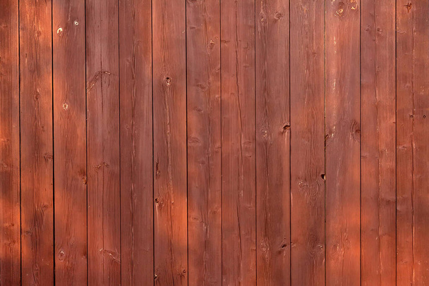Brown wooden vertical plank fence with sun glare - Photo, Image