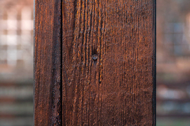 Tablón vertical de madera marrón con resplandor solar con clavo
. - Foto, imagen