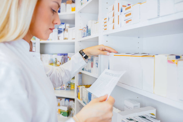 Pharmacists searching for medication by prescription in drugstore - Photo, Image