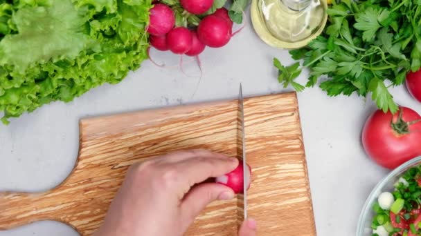 Directly above shot of woman cutting radish on chopping board - Footage, Video