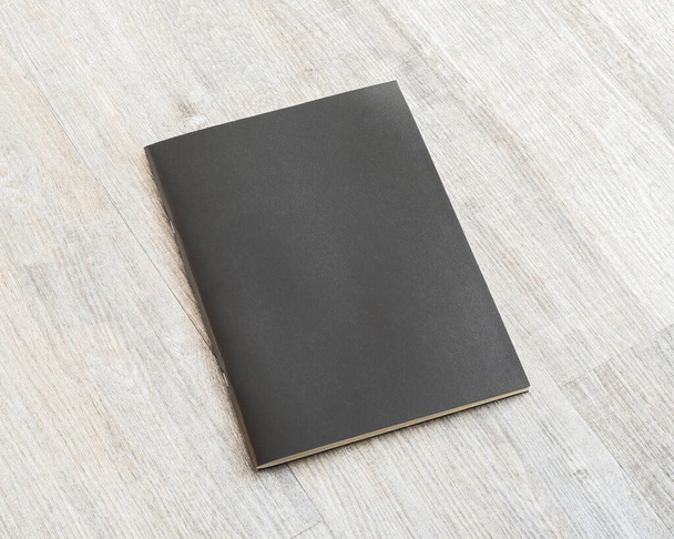 Mockup book with blank black leather cover template paper texture on wood table  - Foto, Imagem