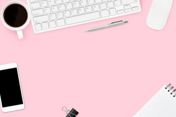 Rosa pastellfarbener Schreibtisch für Frauen mit Computergeräten, Kaffee, Smartphone und Zubehör. Draufsicht mit Kopierraum, flache Lage. - Foto, Bild