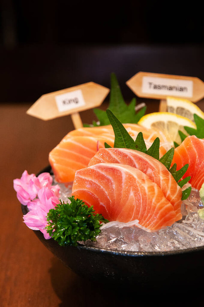 Salmón japonés premium Sashimi King Salmón, salmón de Tasmania, salmón noruego sobre hielo en tazón de cerámica negra
. - Foto, Imagen