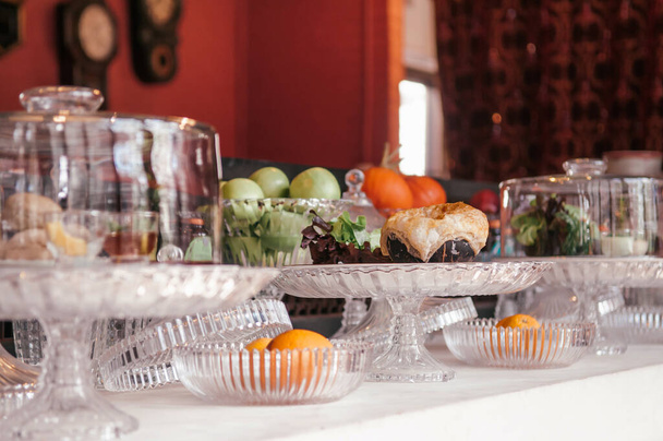 Ζαχαροπλαστείο μπαρ και διάφορα γλυκά σφολιάτας, φρούτα σε πολυτελές γυάλινο δίσκο βάθρο σε vintage διακόσμηση αρτοποιείο - Φωτογραφία, εικόνα