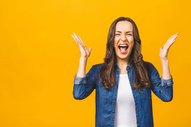 I'm winner! Happy successful young woman with raised hands shouting and celebrating success over yellow background. - Foto, Imagem