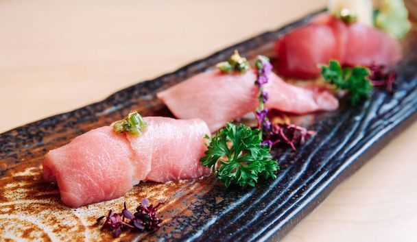 Świeże piękne kawałki japońskiego sushi Otoro tuńczyka na płycie ceramicznej rzemiosła, strzał z bliska - Zdjęcie, obraz