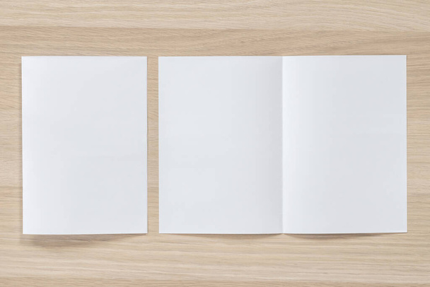 Simular folleto folleto folleto diseño A4 tamaño medio plegado (A5) espacio de diseño de papel para la plantilla de ilustración maqueta, plano sobre tabla de madera desde la vista superior - Foto, Imagen