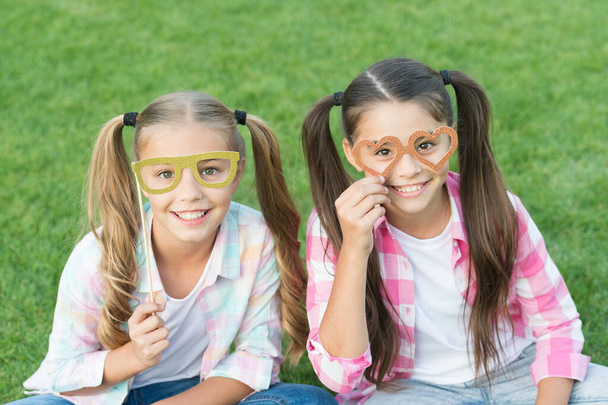 Summer party. Happy children hold prop glasses. Party photobooth. Party girls celebrate on green grass. Party look. Fun and entertainment. Carnival fashion accessories. Fancy beauty - Foto, Bild