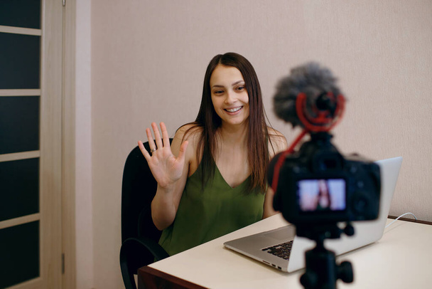 eine junge Bloggerin nimmt Videos zu Hause auf, bei der Arbeit in der Ferne, ein Mädchen ist im Videokonferenzmodus, eine beliebte Bloggerin führt einen Videostream durch - Foto, Bild