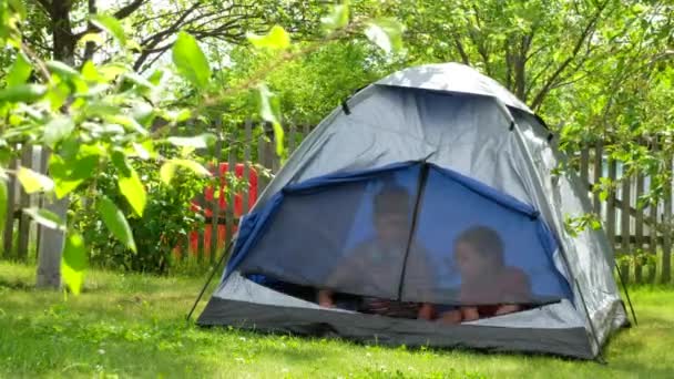 Brother and sister at camping in summer. Children are playing in a tent. - Footage, Video