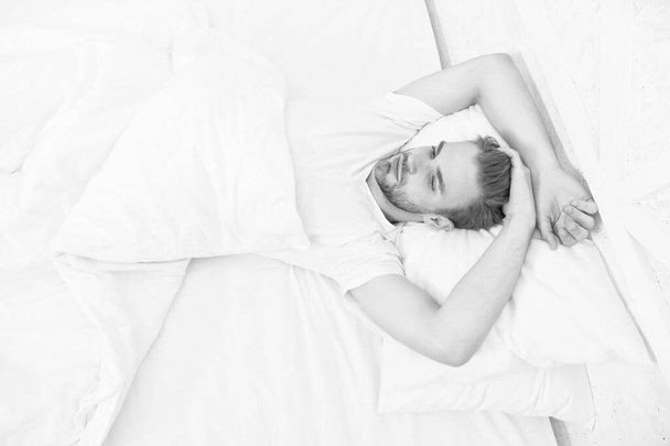 Tips promoting healthful sleep habits. Handsome man relaxing in bed. Establish regular nightly sleep pattern. Practice calming activities such as meditation before going to bed. Healthy sleep concept - Photo, image