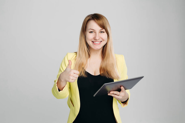 Retrato de mujer, sosteniendo la tableta y apuntando con el dedo hacia arriba
. - Foto, imagen