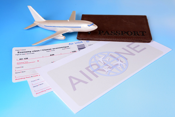 Vliegtickets met paspoort op lichtblauwe achtergrond - Foto, afbeelding