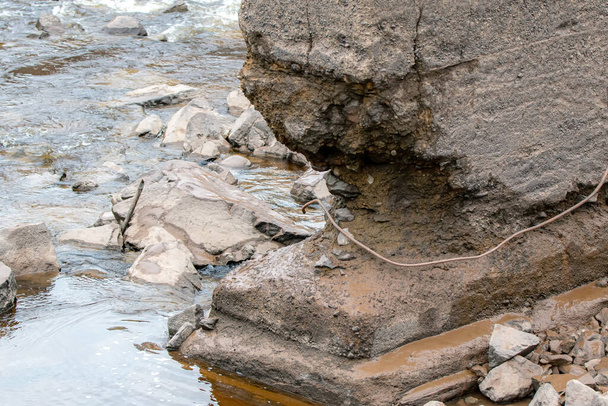 El fondo de un puente de hormigón erosionado de apoyo en un río. El soporte está muy erosionado en la parte inferior
. - Foto, imagen