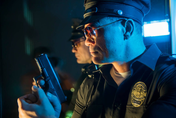 θυμωμένος αστυνομικός με όπλο στο χέρι, αστυνομικός   - Φωτογραφία, εικόνα