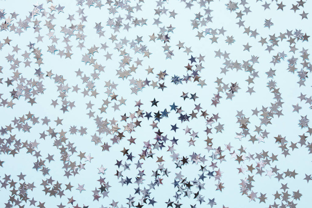 Zilveren folie confetti sterren op blauwe achtergrond - Foto, afbeelding