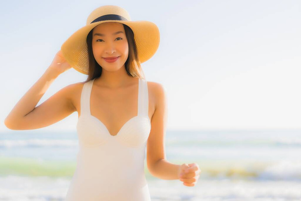 Portrét krásná mladá asijská žena šťastný úsměv kolem moře oceán pláž a modrá obloha pro volný čas cestování dovolená - Fotografie, Obrázek