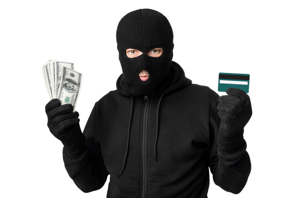 Voleur masqué montrant de l'argent isolé sur un mur blanc
 - Photo, image