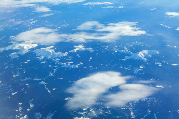 Leichte Wolken über den Bergen, Luftaufnahme der Alpen  - Foto, Bild