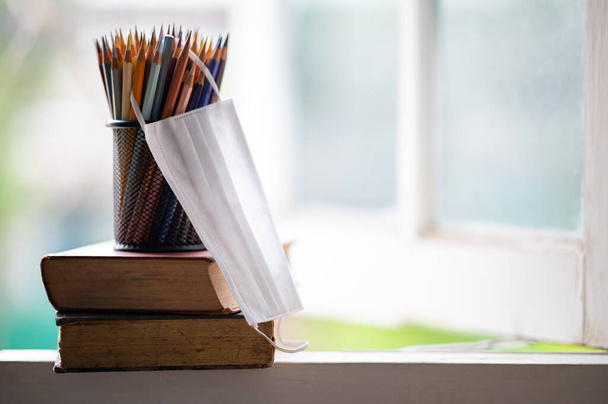 crayon de couleur dans un pot noir et la page d'assainissement placé sur le livre de concept pour apprendre en ligne à la maison
 - Photo, image