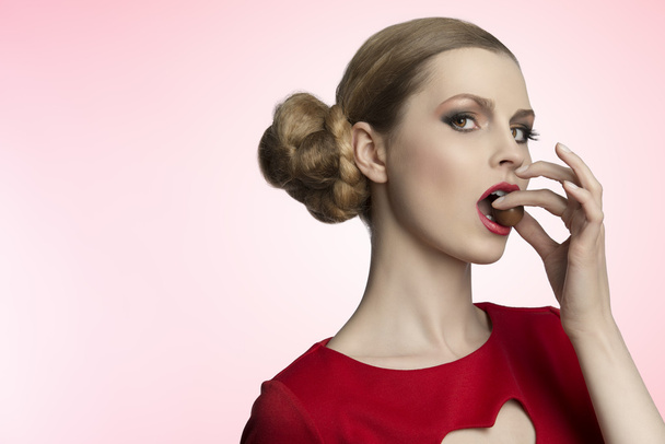 hübsche Frau isst Praline - Foto, Bild