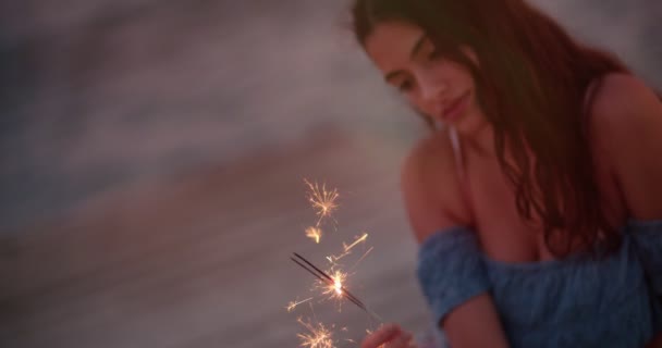 Gyönyörű fiatal nő nyári vakációkon kezében csillagszórók naplemente után - Felvétel, videó