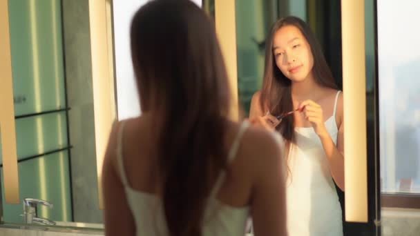 beeldmateriaal van mooi aziatisch vrouw doen make-up in de voorkant van spiegel - Video
