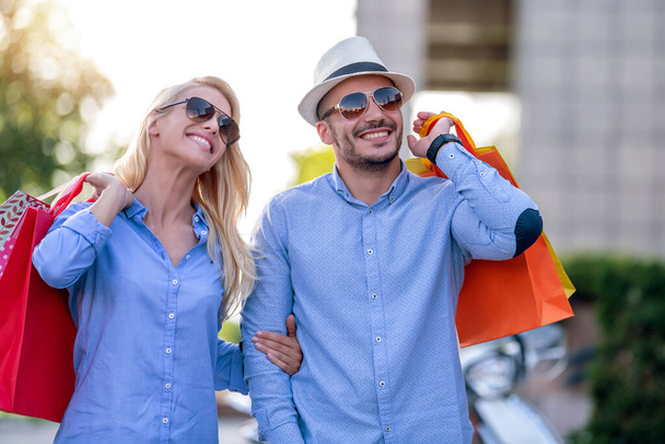 Красива молода пара насолоджується покупками, розважаючись у місті
 - Фото, зображення