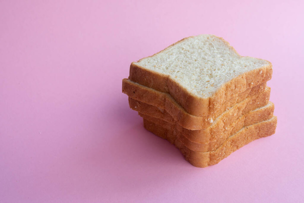 スライスしたパン。トーストサンドイッチ用のパン。ピンクの背景に柔らかいパン - 写真・画像