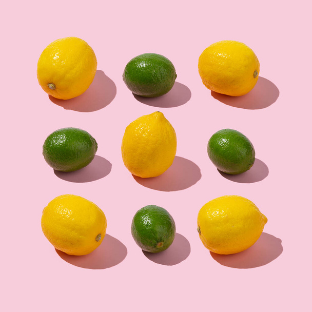 Limes and lemons arrangement on pastel pink background. Creative summer isometric concept. - Фото, изображение