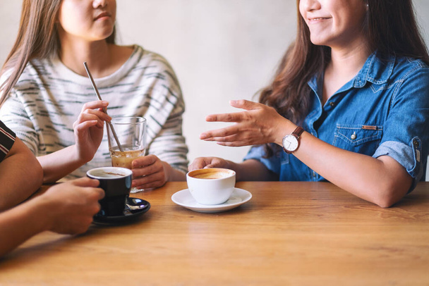 Close-up beeld van vrienden genoten van praten en het drinken van koffie samen in cafe - Foto, afbeelding