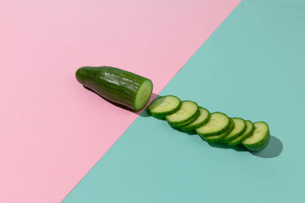 Fresh green cucumber cut on pastel color block abstract background. Fashionable nutrition diet creative concept. - Фото, изображение