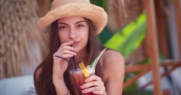 Junge brünette Frau trinkt Sommercocktail auf tropischer Insel - Filmmaterial, Video