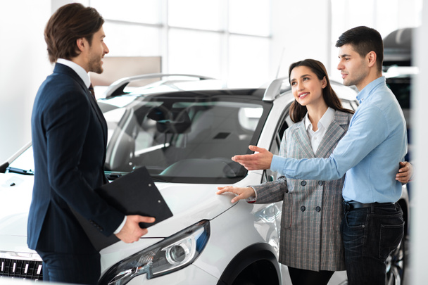 Young Couple Choosing Auto With Professional Dealer - Photo, Image