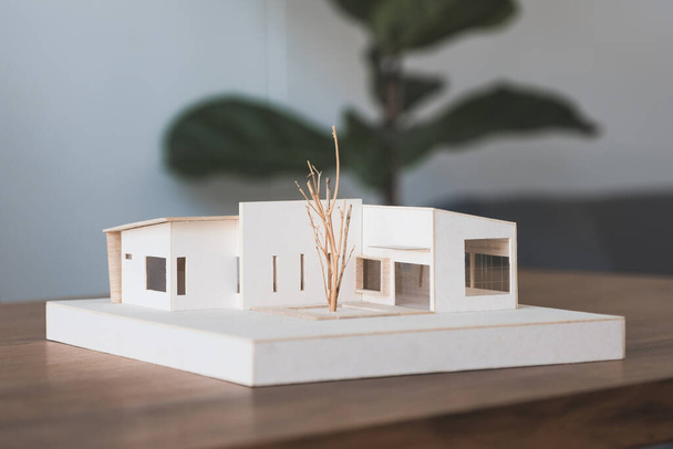 An architecture model on wooden table in office with blur nature background - Fotoğraf, Görsel