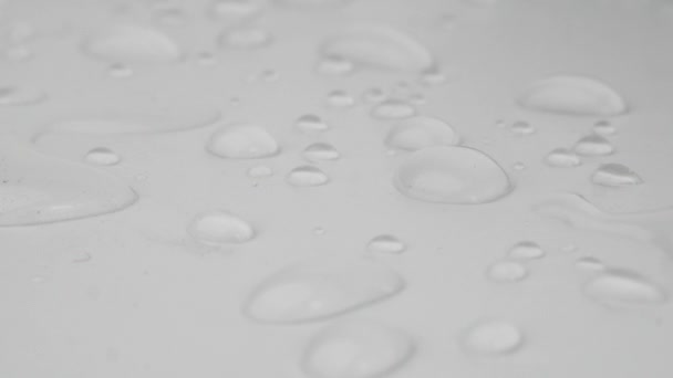 Krople deszczu lub krople wody na białym tle. Skupienie selektywne. - Materiał filmowy, wideo