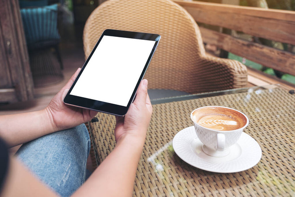 Mockup image of woman's hands holding white mobile phone with blank screen with coffee cup in cafe - Photo, Image