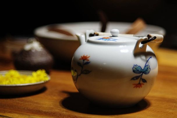 White Ceramic teapot on wooden table in tearoom cafe dark background - Photo, Image