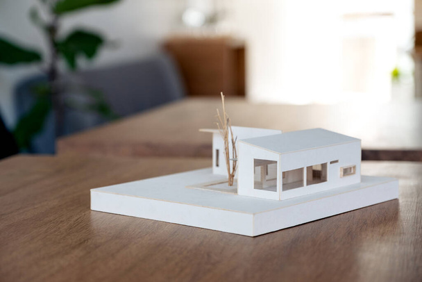 An architecture model on wooden table in office with blur nature background - Photo, Image