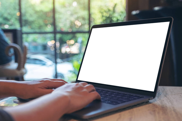 Образец изображения рук, использующих и печатающих на ноутбуке с чистым белым экраном рабочего стола, сидя в кафе
 - Фото, изображение