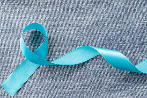 Modrá stuha symbolizující kampaň povědomí o rakovině prostaty a zdraví mužů v listopadu měsíce na džínách denim  - Fotografie, Obrázek