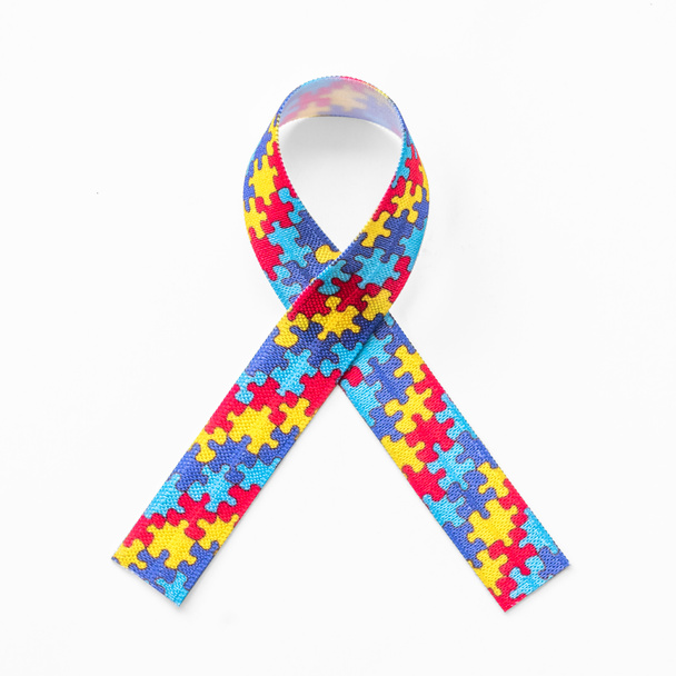 Autism awareness ribbon in puzzle or jigsaw pattern (isolated on white background with clipping path) for World Autism Awareness day, mental health care concept for autistic child person support and family nursing care - Photo, image