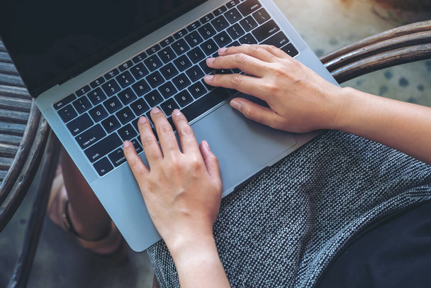 Widok z góry obraz kobiety za pomocą i wpisując na klawiaturze laptopa podczas siedzenia w plenerze - Zdjęcie, obraz