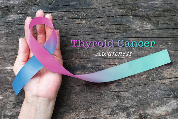 甲状腺がん啓発リボン女性の手のサポートにティールピンクブルーのリボン(クリッピングパスで隔離)  - 写真・画像