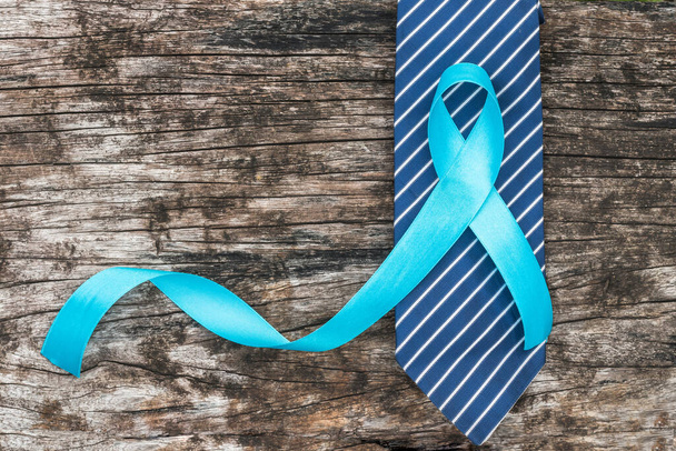 Prostate cancer awareness concept with light blue ribbon on necktie and old aged wood for men's health care campaign in November and September month - Φωτογραφία, εικόνα