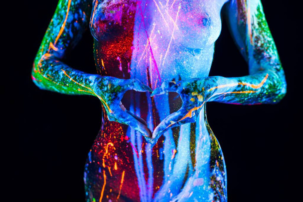 Γυναικείο σώμα με υπεριώδες χρώμα bodyart και τα χέρια στο σύμβολο της καρδιάς - Φωτογραφία, εικόνα