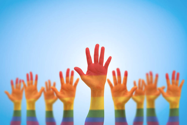 LGBT equal rights movement and gender equality concept with rainbow flag on people's hands up - Photo, Image